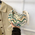 Women's straw woven crossbody bag showing knitted weaving texture and internal phone pocket