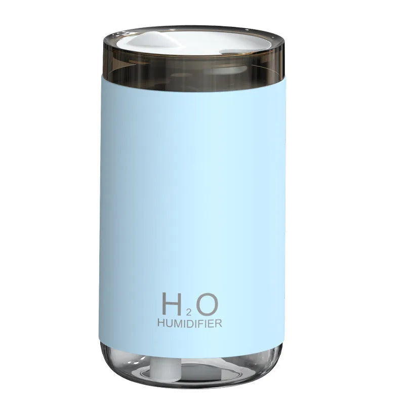 Blue jellyfish humidifier on a table emitting smoke ring mist with warm night light glow