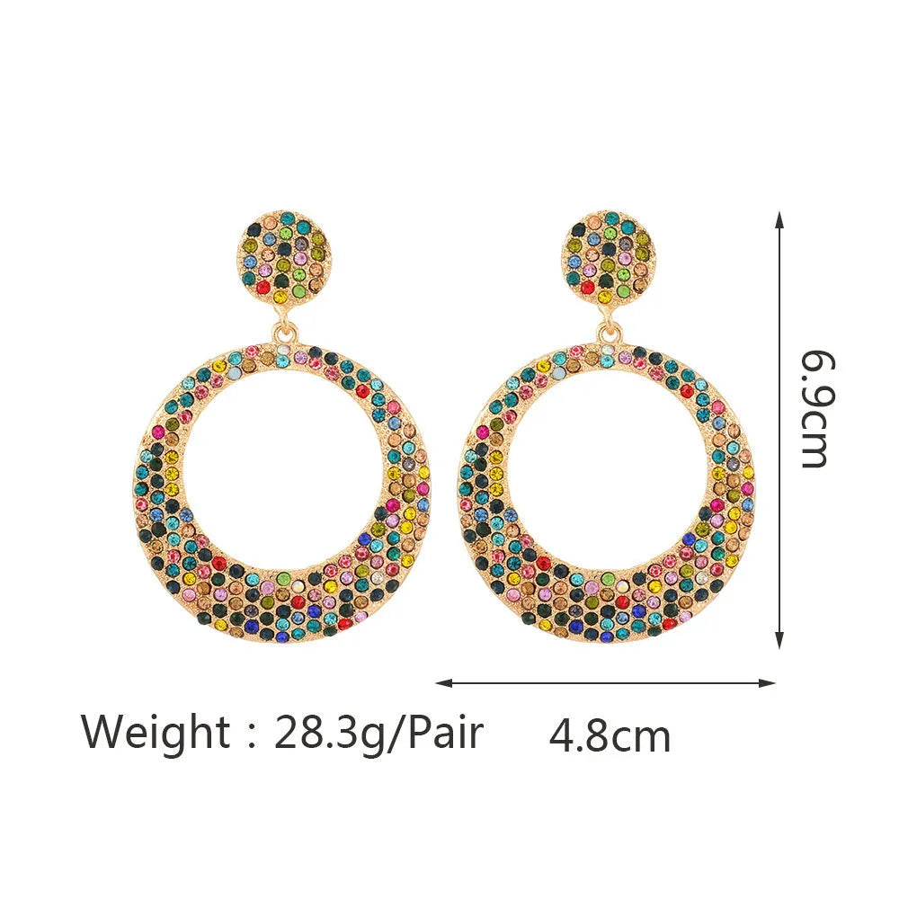 A pair of large colourful round pendant drop earrings with a cartoon style, made from metal alloy.