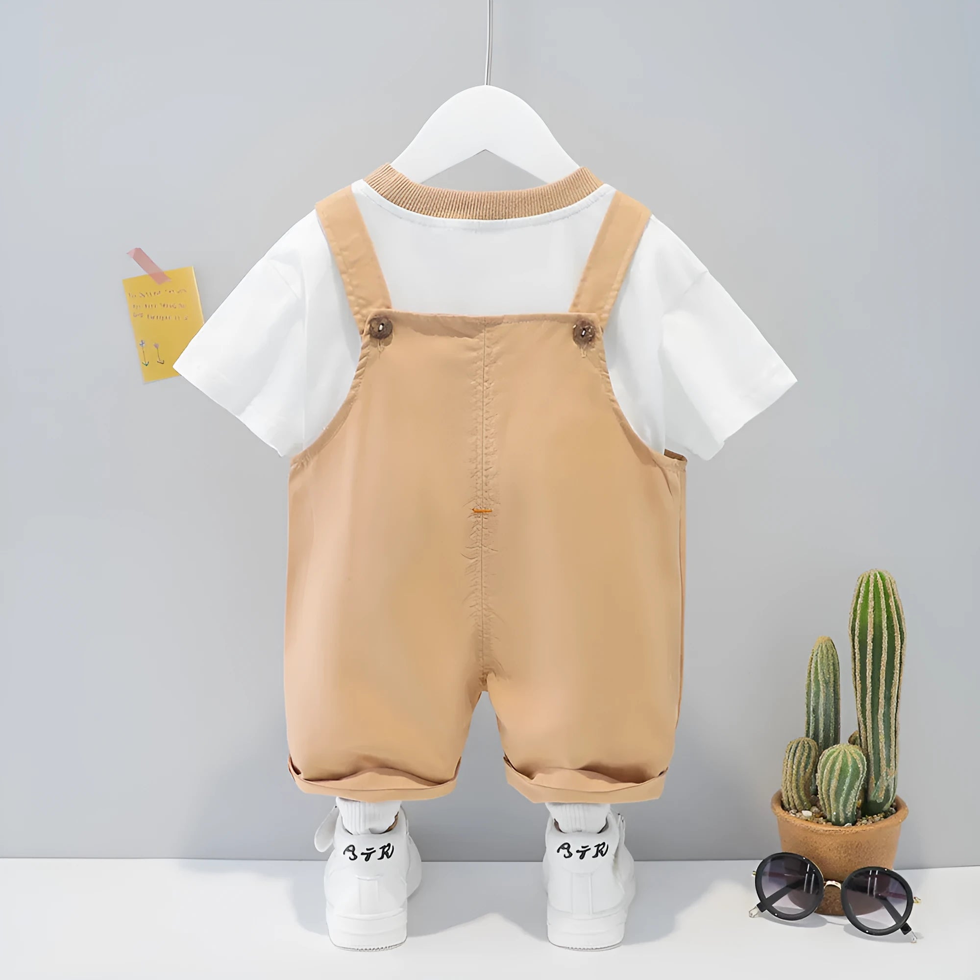 Yellow children's cotton short-sleeved overalls with cartoon print and detachable straps.