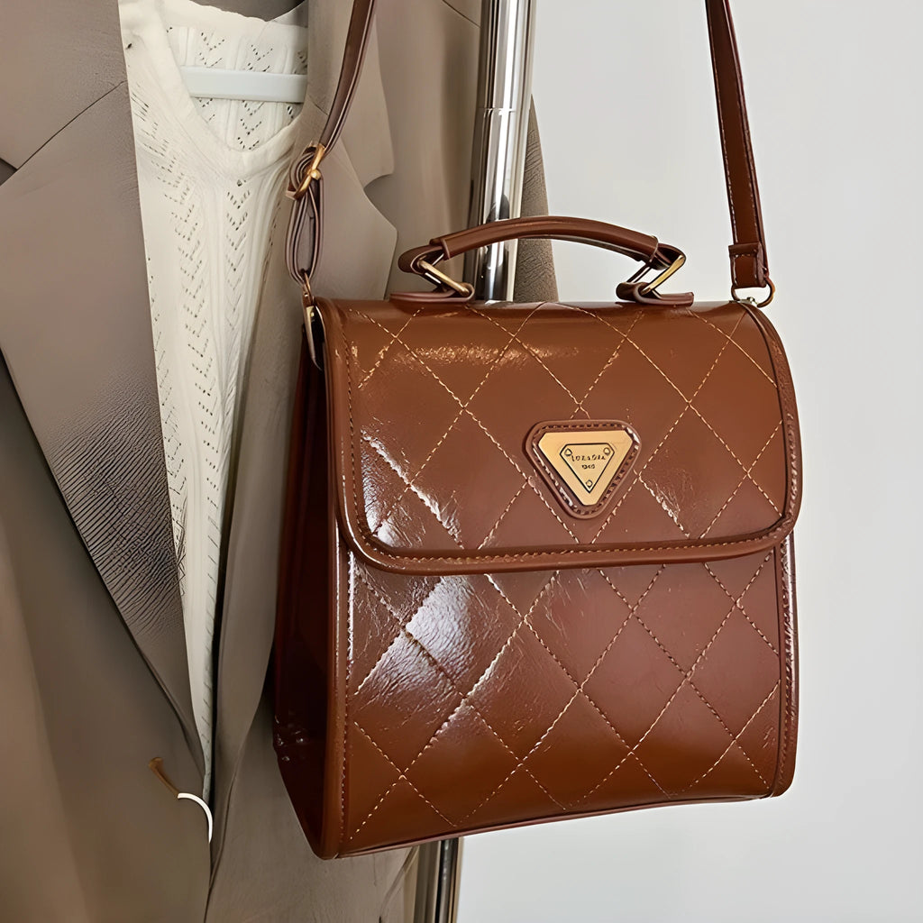 PU mini backpack in brown with stitching detail and pendant, front view