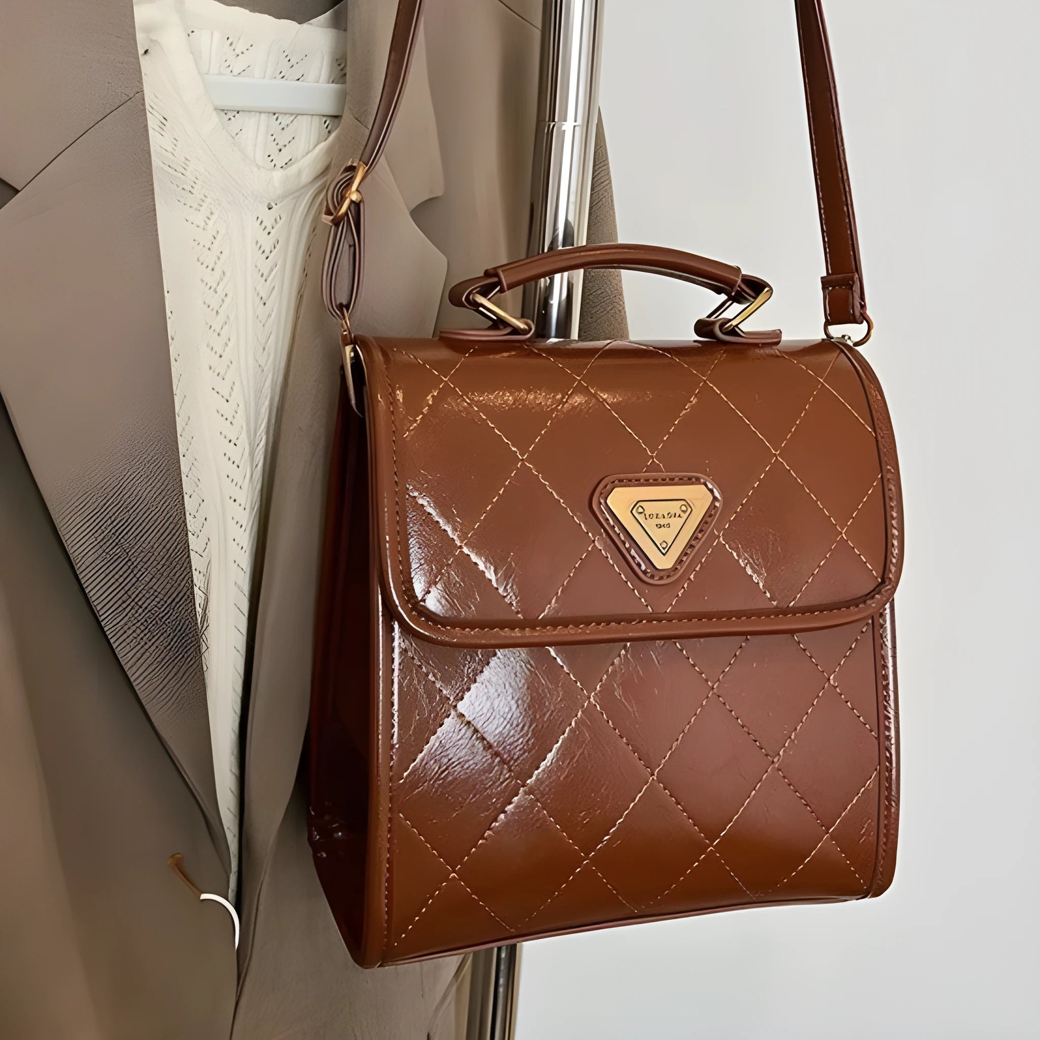 PU mini backpack in brown with stitching detail and pendant, front view