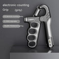 Orange electronic counter spring grip for hand strength training on a grey background.