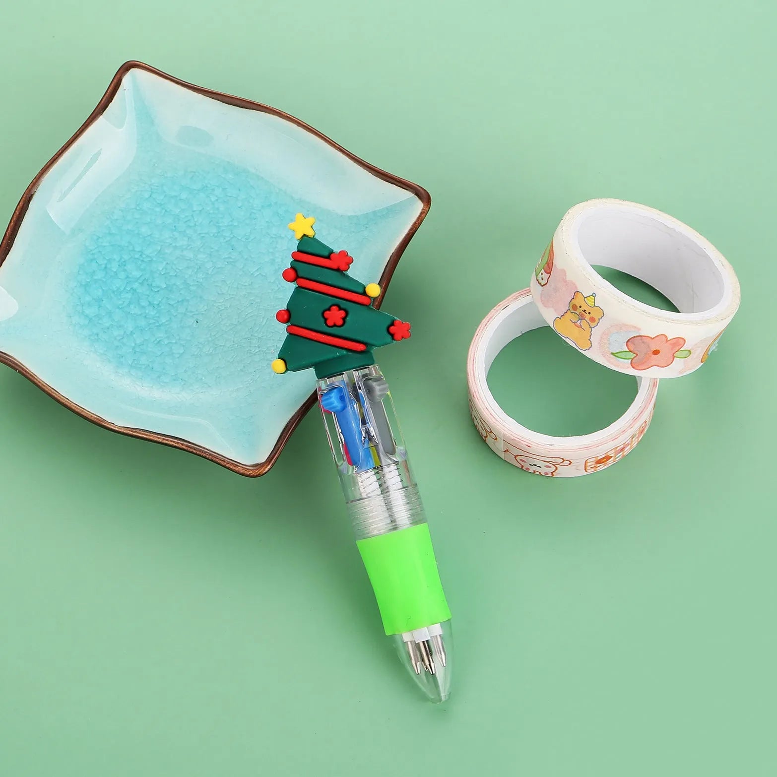 Christmas-themed ballpoint pen with press button, showing designs of snowmen, reindeer, and trees on plastic barrel.