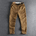 Men's khaki and dark blue cotton casual trousers with a mid-waist fit and zip fly.