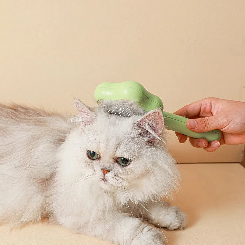 Green self-cleaning stainless steel pet comb with a magic wand handle on a white background.