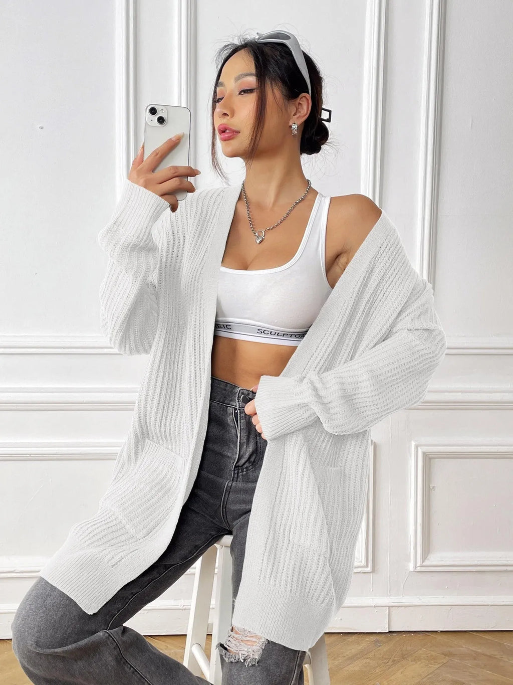 Women's dark green two-pocket acrylic cardigan sweater with loose fit and long sleeves