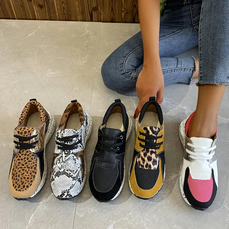 Women's black suede casual sneakers with a wedge heel and round toe on a light background.