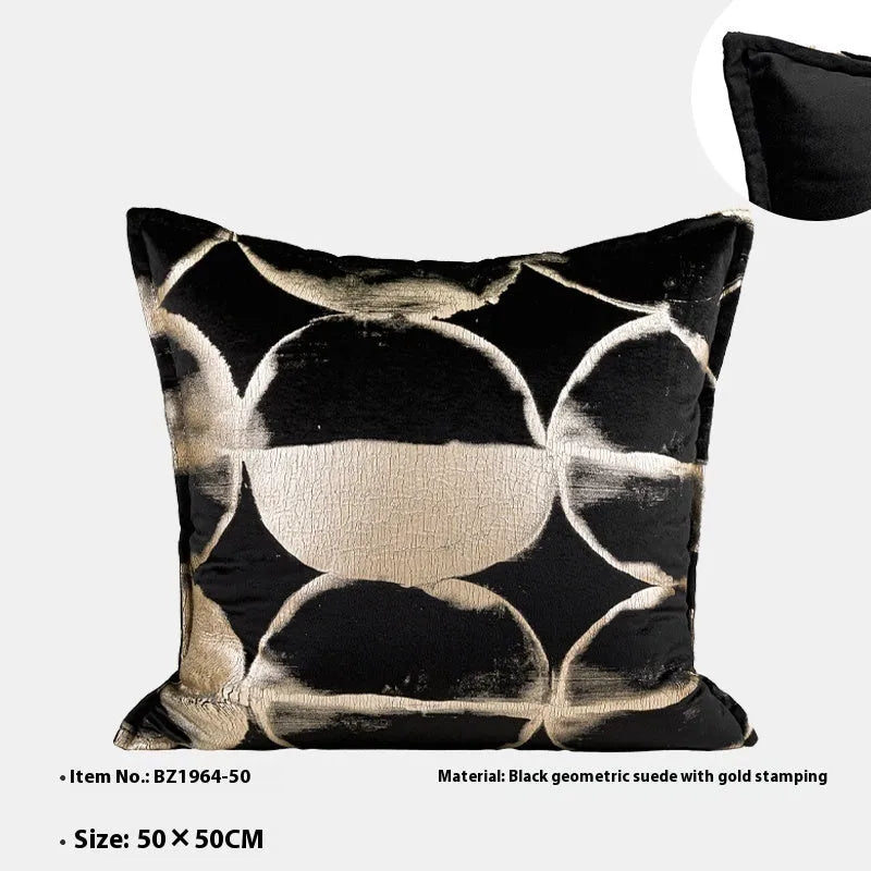 Black and gold abstract patterned flannel cushion in square and bolster sizes on a grey sofa.