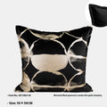 Black and gold abstract patterned flannel cushion in square and bolster sizes on a grey sofa.