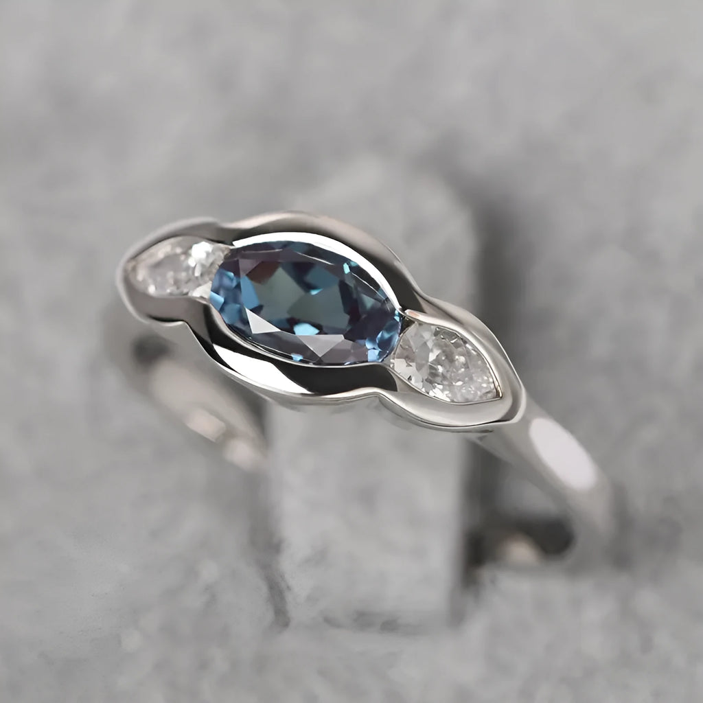 Geometric ellipse women's ring with a central zircon stone and white gold plating.