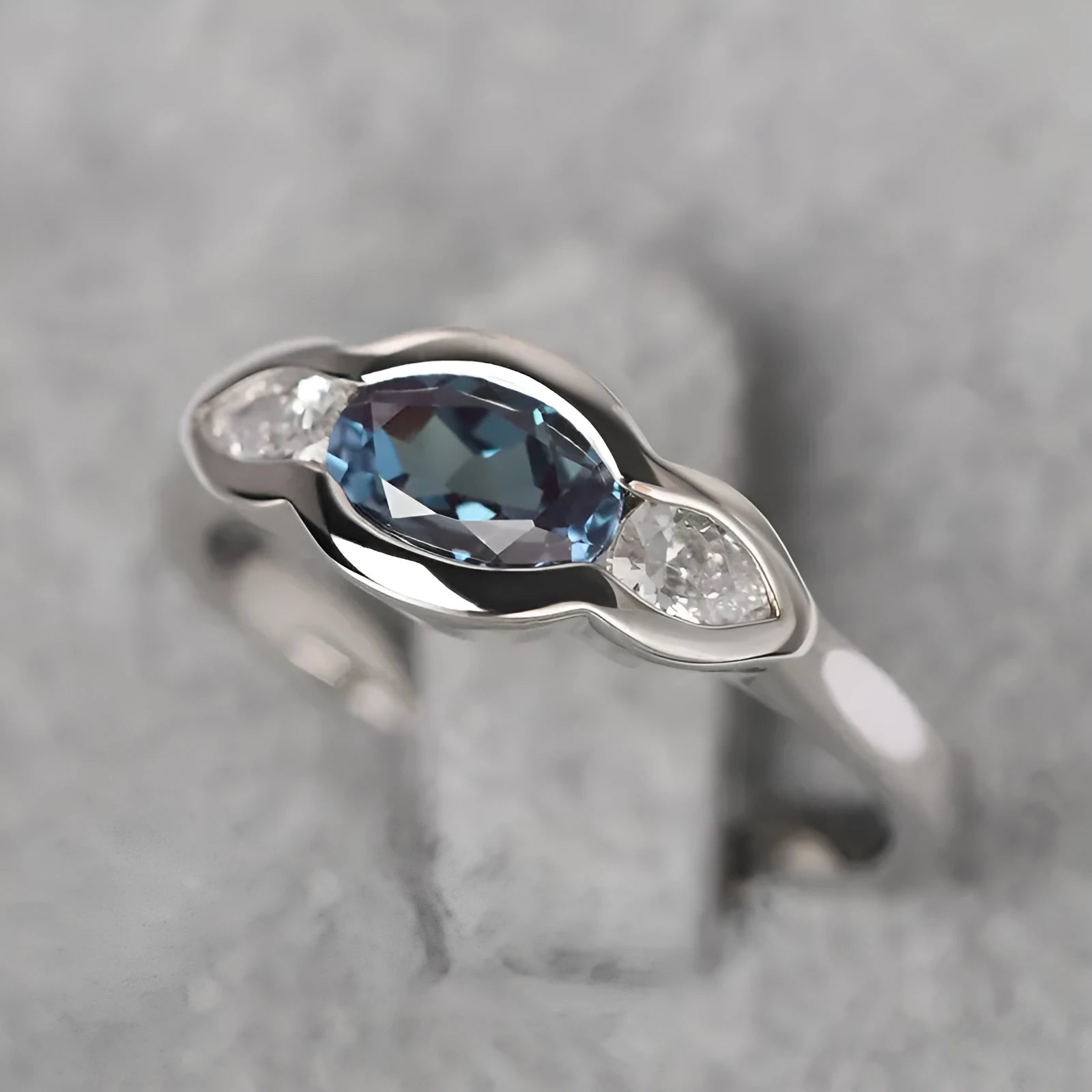 Geometric ellipse women's ring with a central zircon stone and white gold plating.