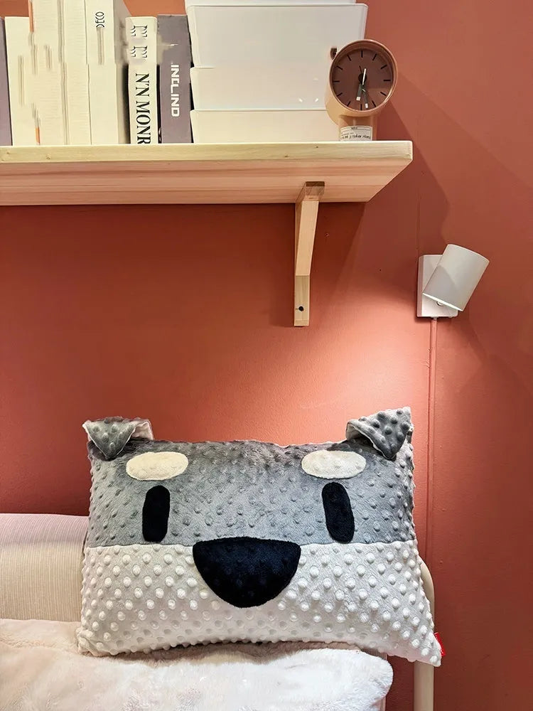 Grey or white West Highland puppy shaped pillow on a sofa, 50cm long.