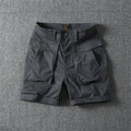 Men's army green cotton cargo shorts with multiple pockets, shown in a straight-leg summer street style.