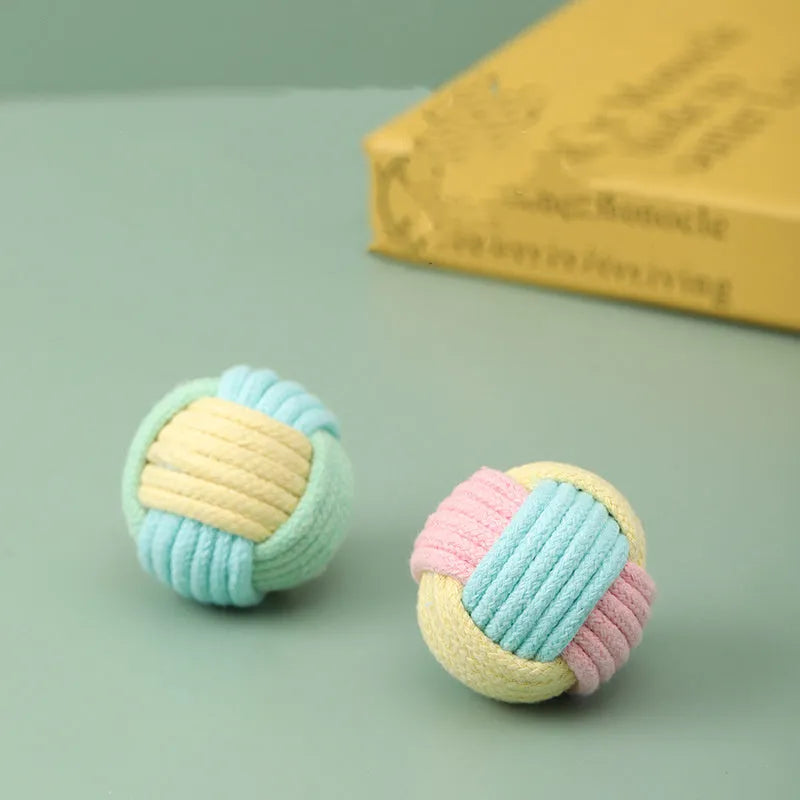 Small handmade blue and pink cotton plush ball cat toy for play and teeth grinding, shown next to a 5cm scale.