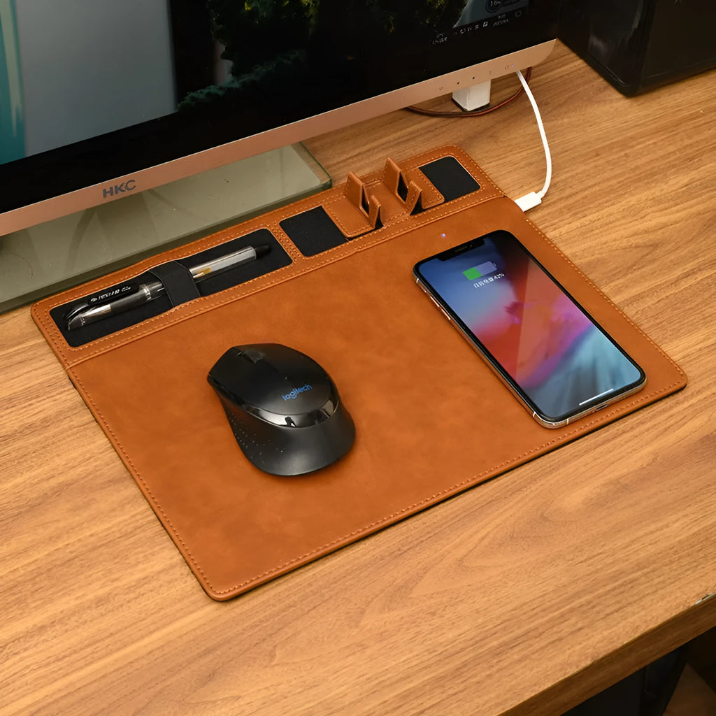 Pink wireless charging mouse pad with phone holder on a desk, showing USB cable connection