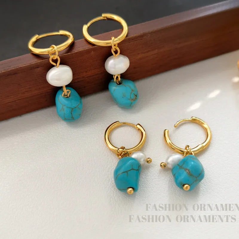 A pair of women's geometric drop earrings with irregular turquoise stones and round cultured pearls on copper settings.
