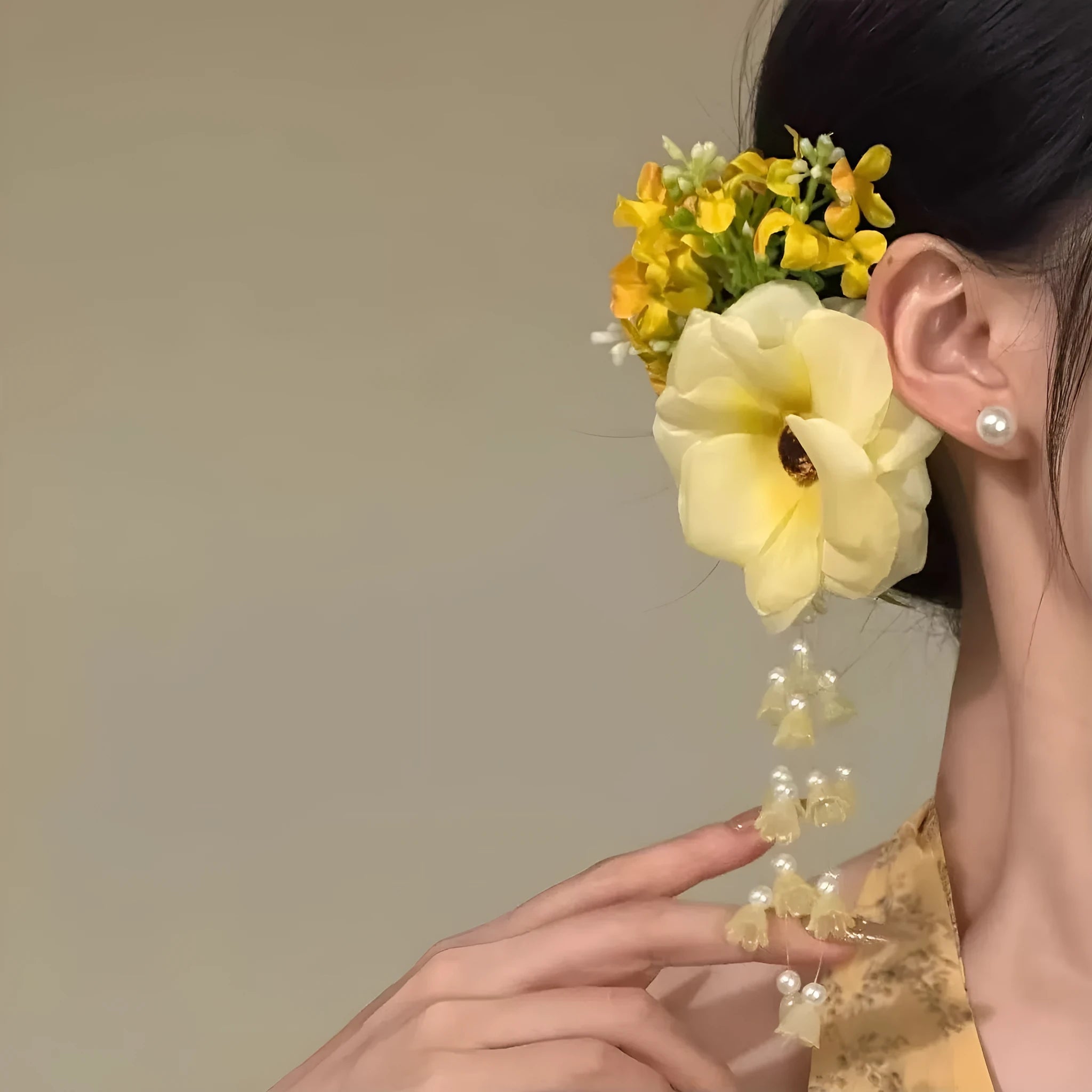 Women's fairy-themed hair clip with long flower tassels and pearl details on a side clip fastener.