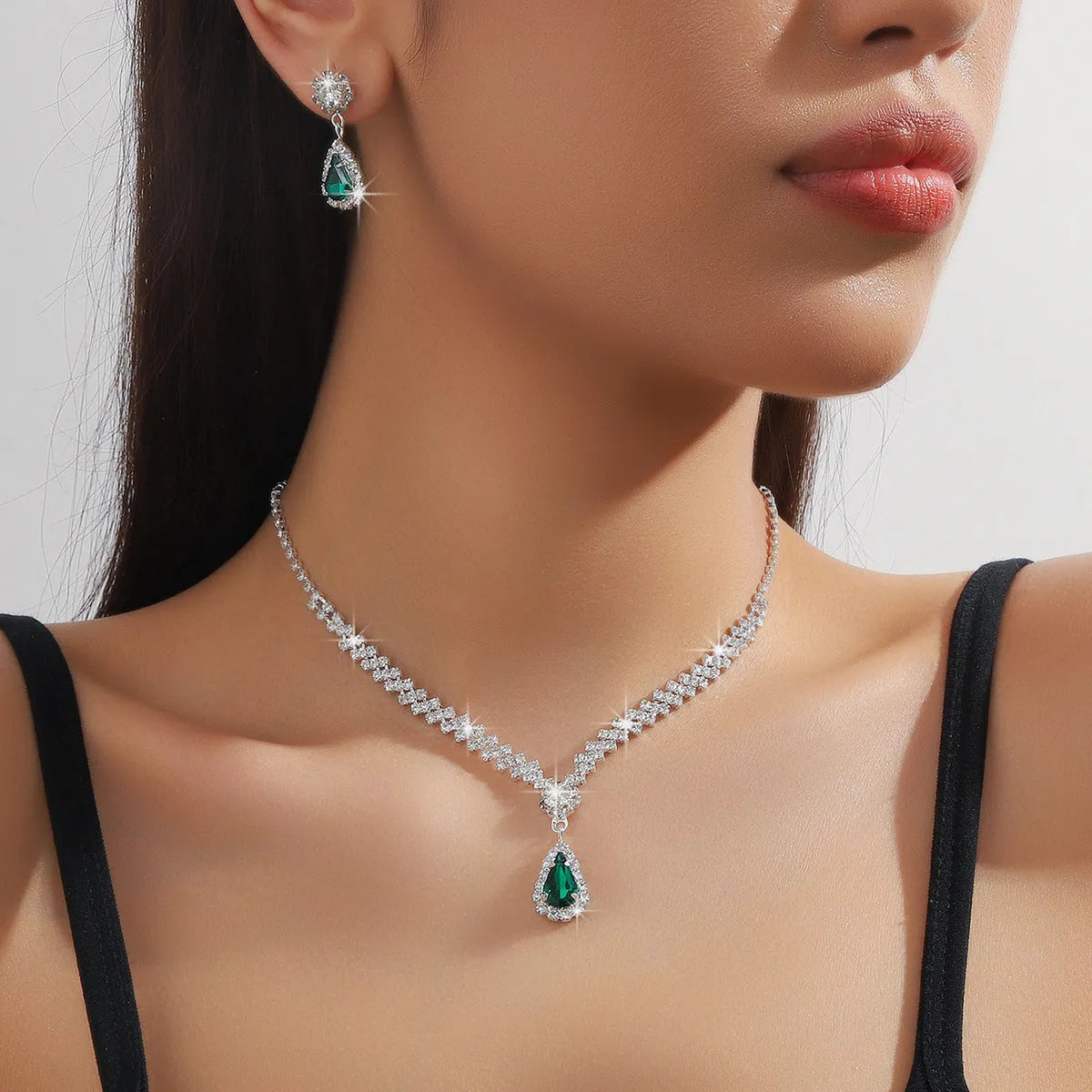 Women's blue claw chain necklace and drop rhinestone earrings from a matching jewellery set.