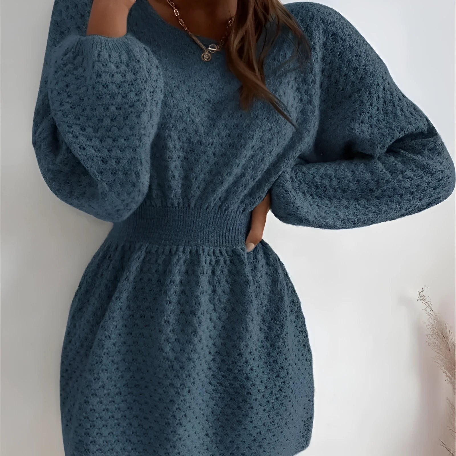 Blue women's knitted dress with French round neck, fitted waist, and crocheted flower details