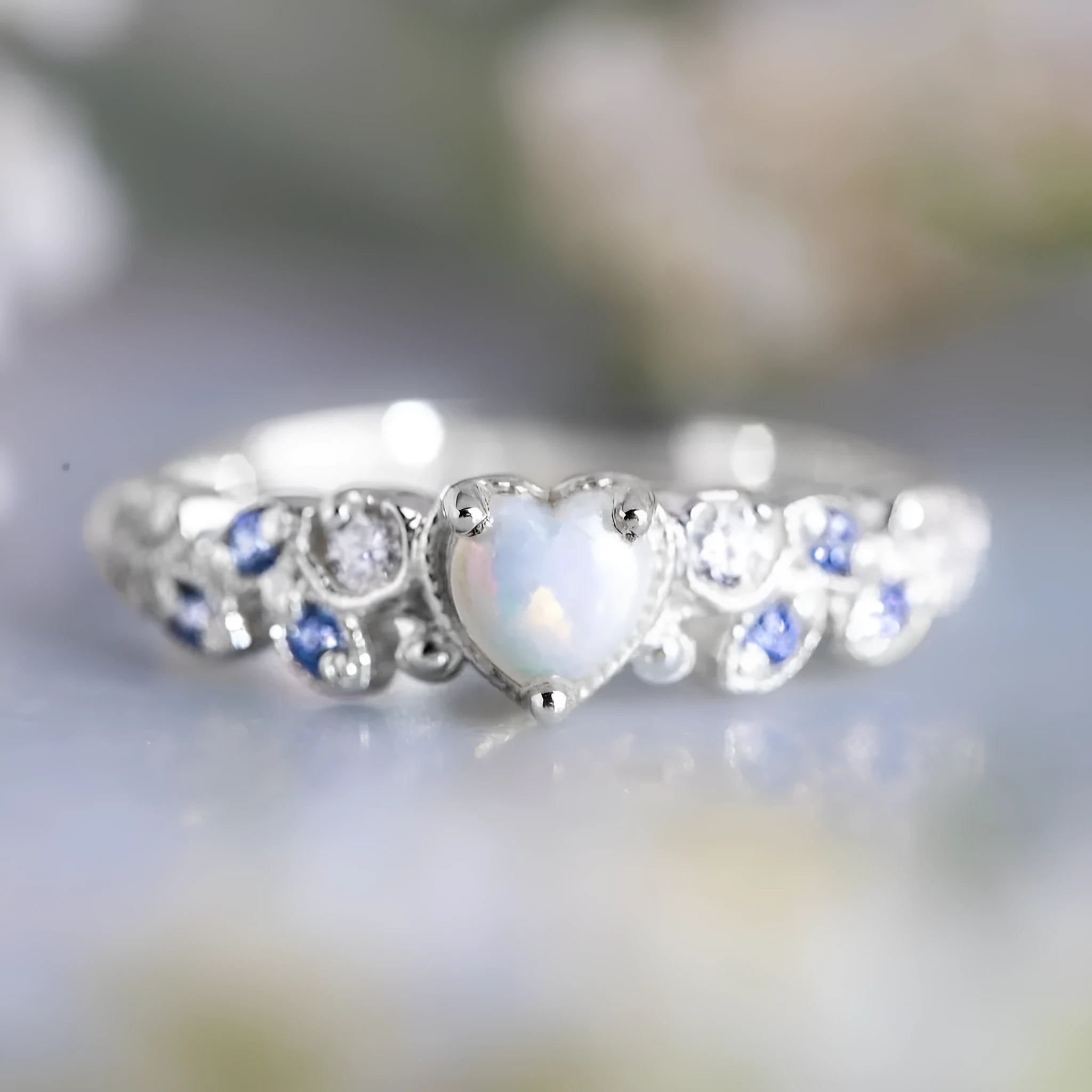 Peach-coloured women's heart-shaped ring with a detailed flower opal ocean design on its surface.