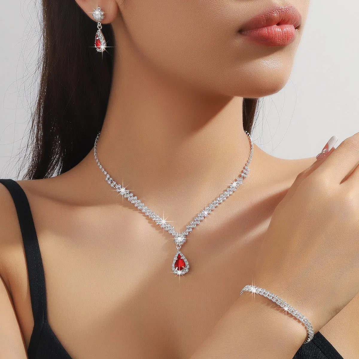 Women's blue claw chain necklace and drop rhinestone earrings from a matching jewellery set.