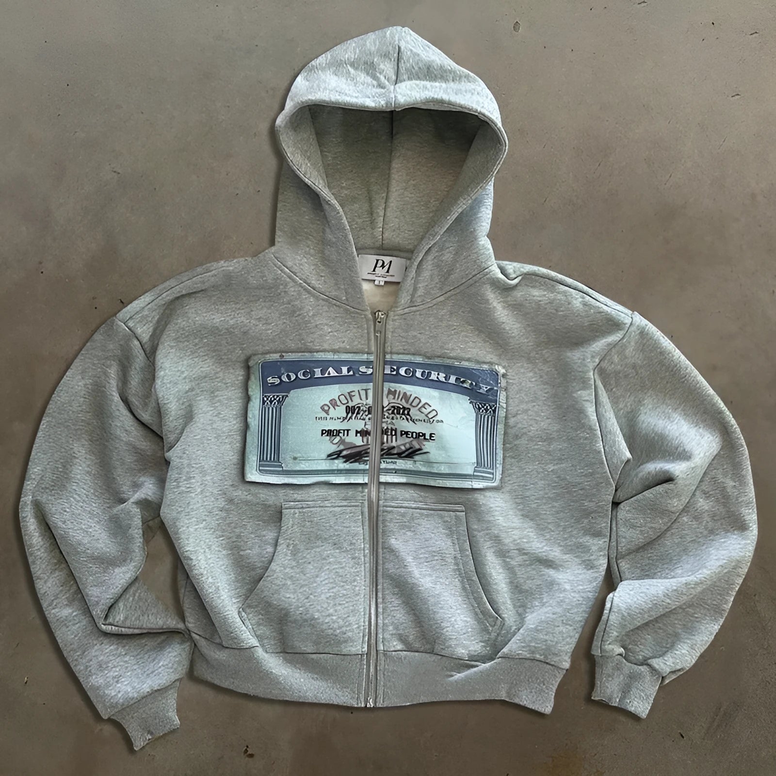 A black loose-fitting zip-up hoodie jacket for men and women with front zipper pockets.