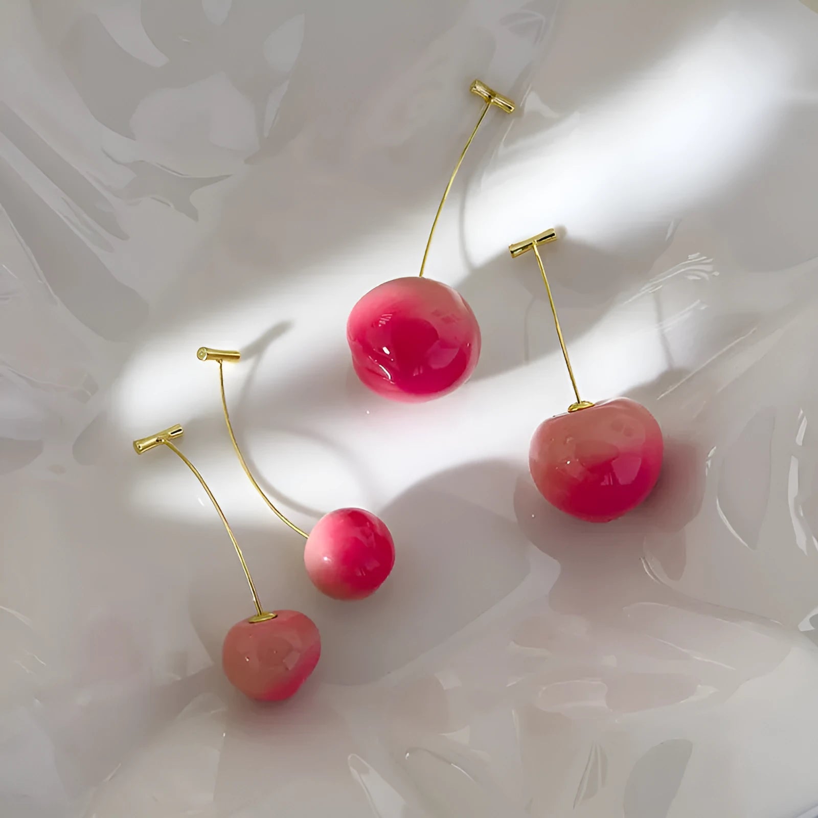 A pair of acrylic peach-shaped earrings with copper fittings, shown in small and large size options.