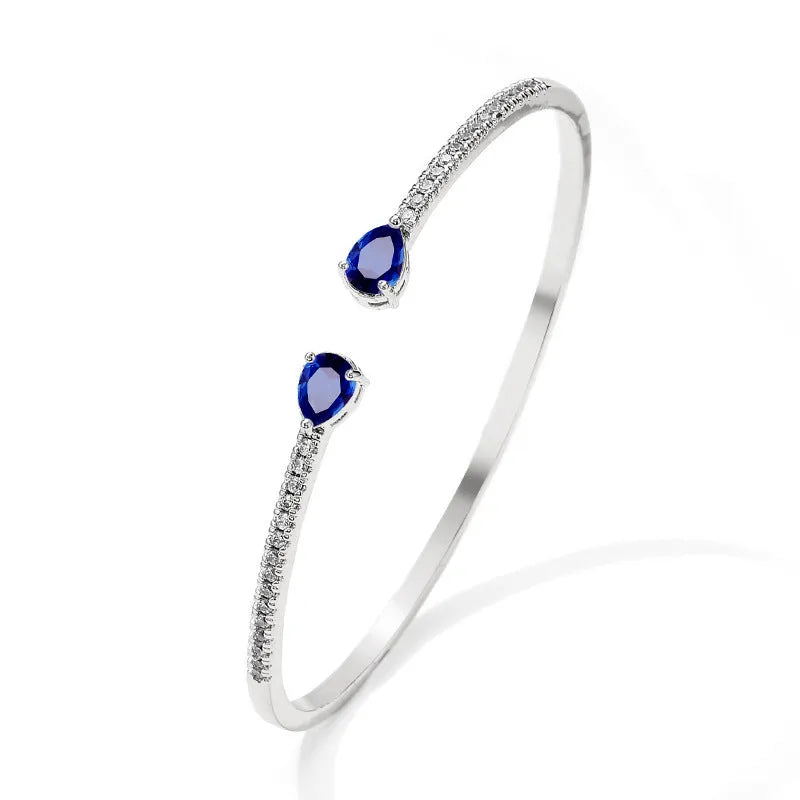 Copper bracelet with inlaid white zircon stones on a wrist.
