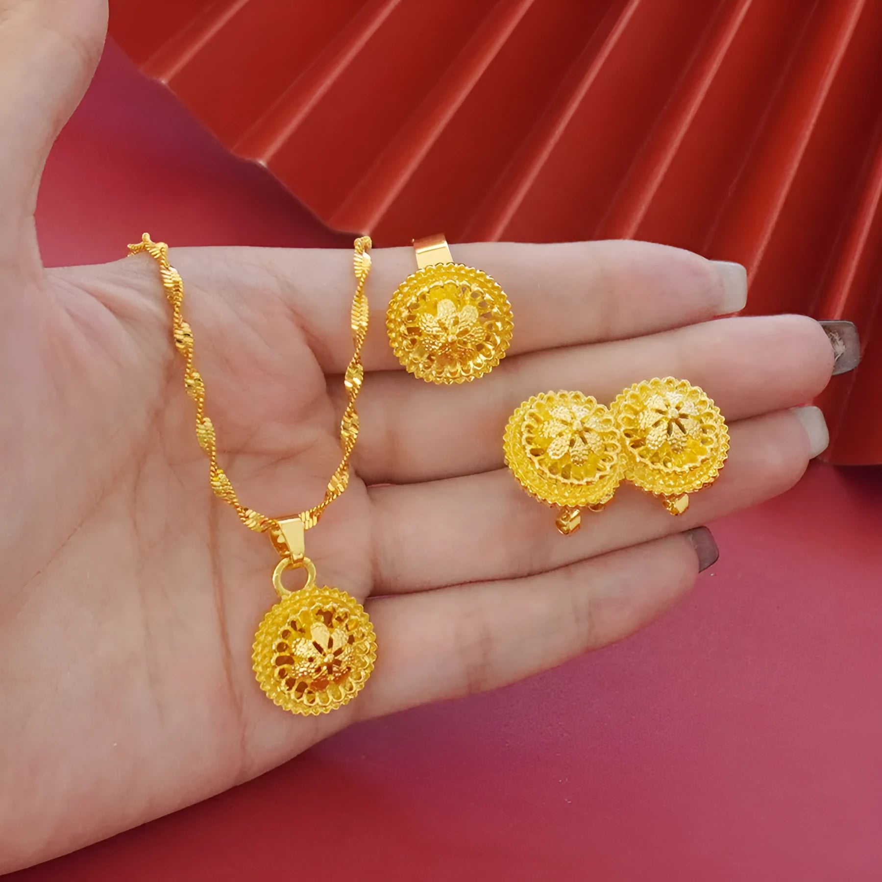 Gold-plated three-piece jewellery suit with landscape Middle East flower designs showing earrings, ring and pendant necklace