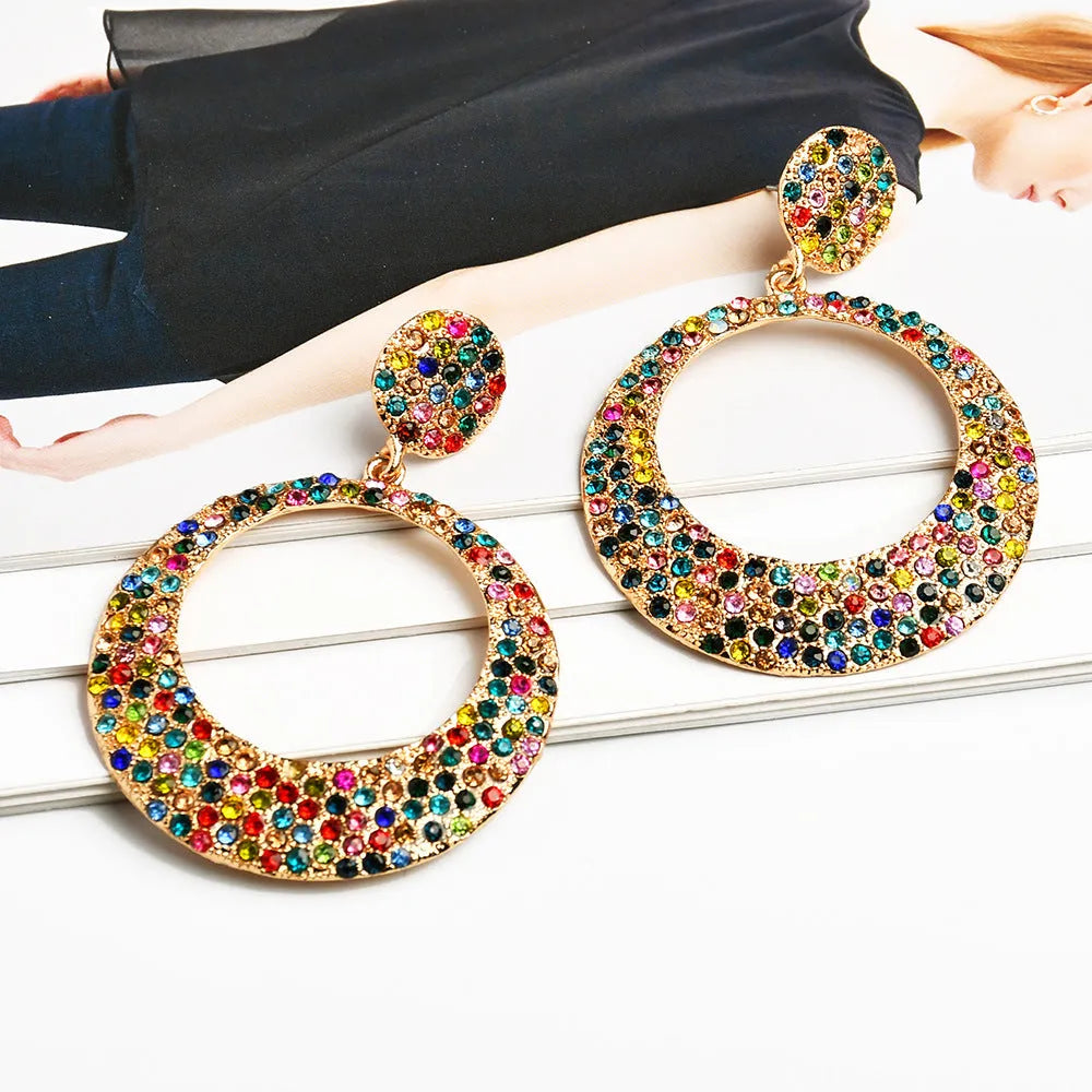 A pair of large colourful round pendant drop earrings with a cartoon style, made from metal alloy.