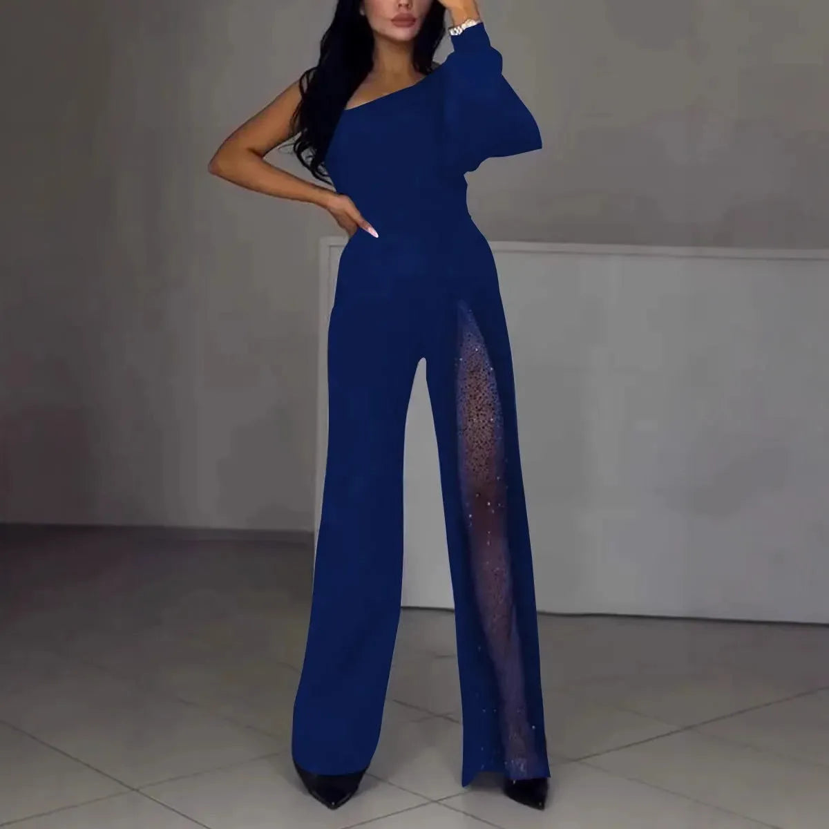 Black women's jumpsuit with one shoulder cut and high leg slit, made from polyester fabric.