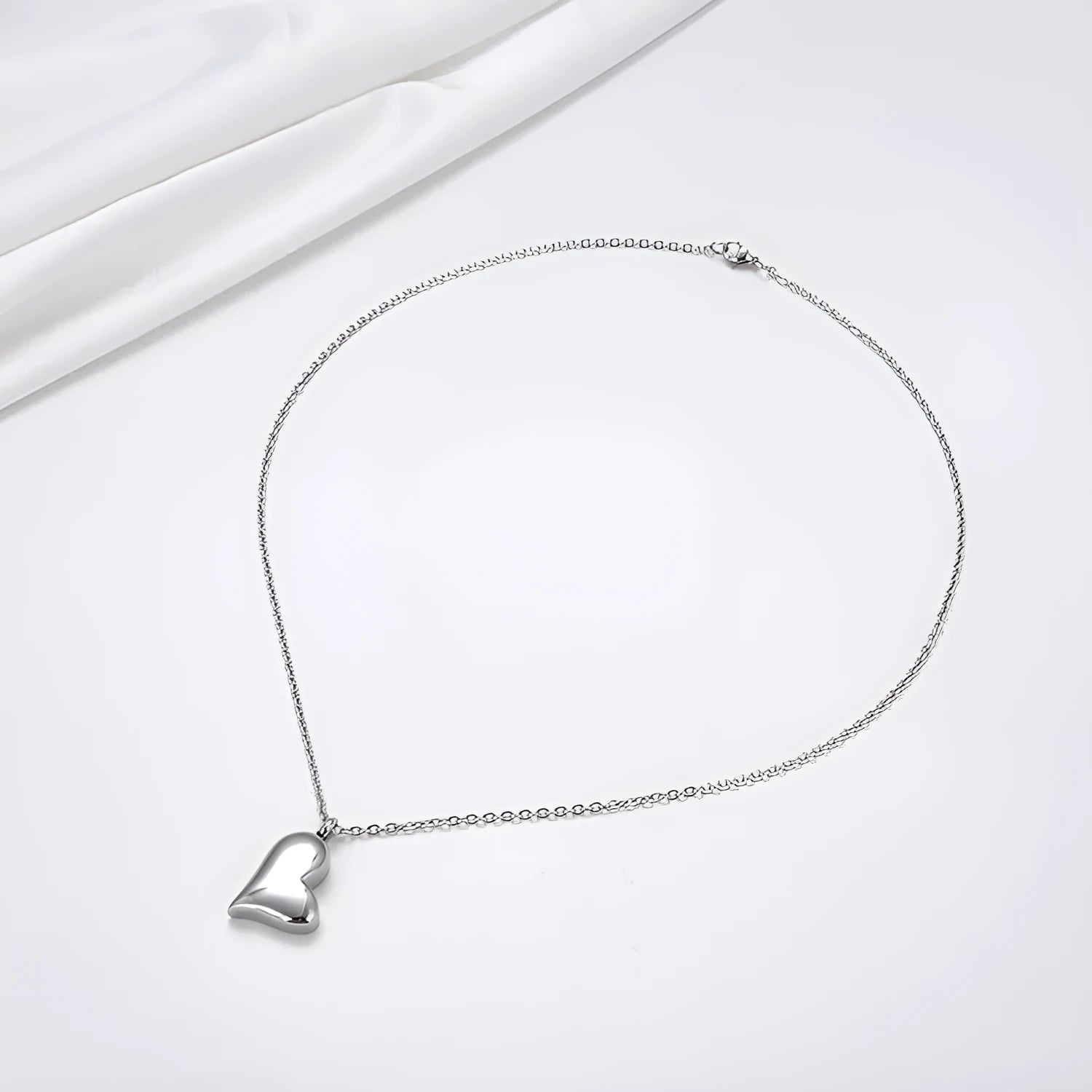 Silver stainless steel curved peach heart pendant necklace on a chain with extension