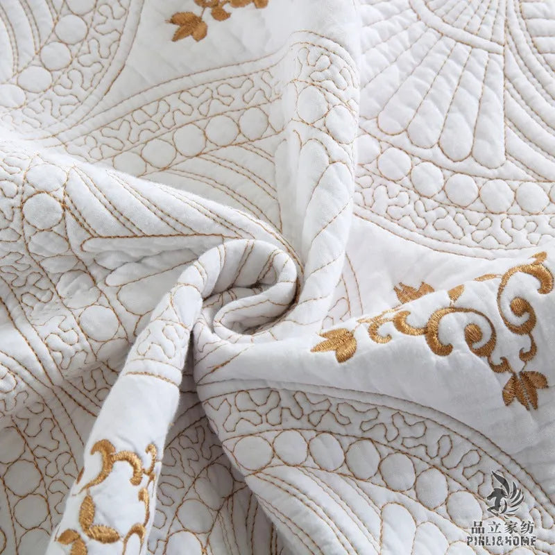 Double thick pure cotton European-style embroidered bed cover set with two pillowcases on a bed.