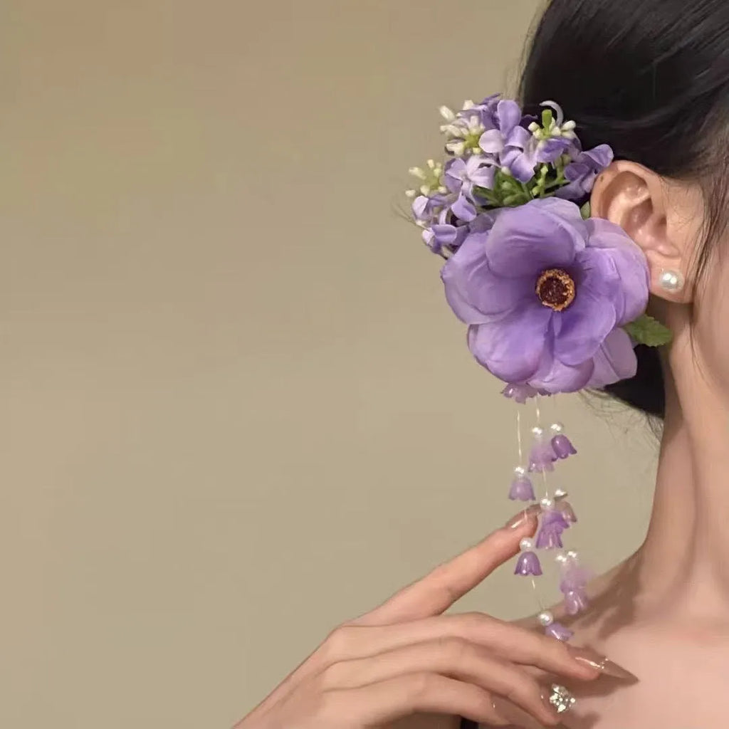 Women's fairy-themed hair clip with long flower tassels and pearl details on a side clip fastener.