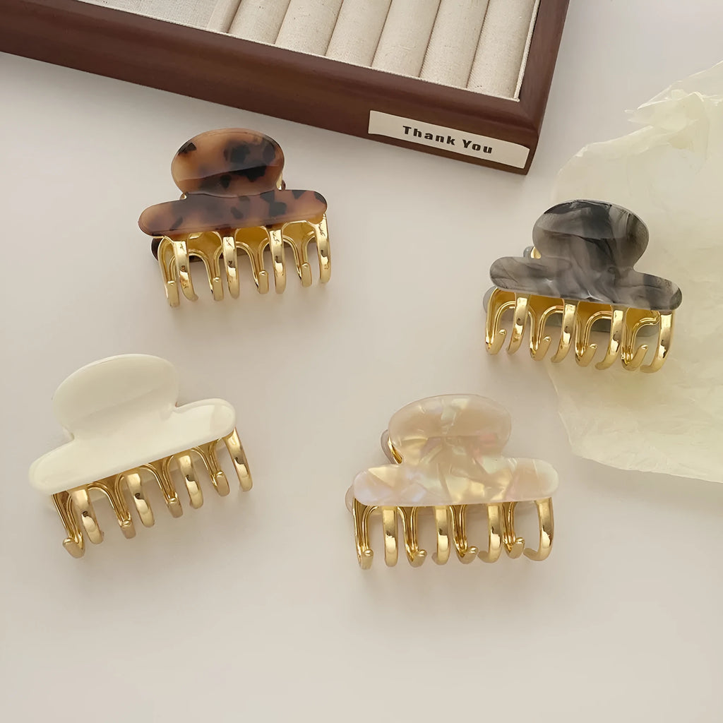 Set of four retro acetate hair barrettes with metal grip in beige, white, dark, and leopard print designs