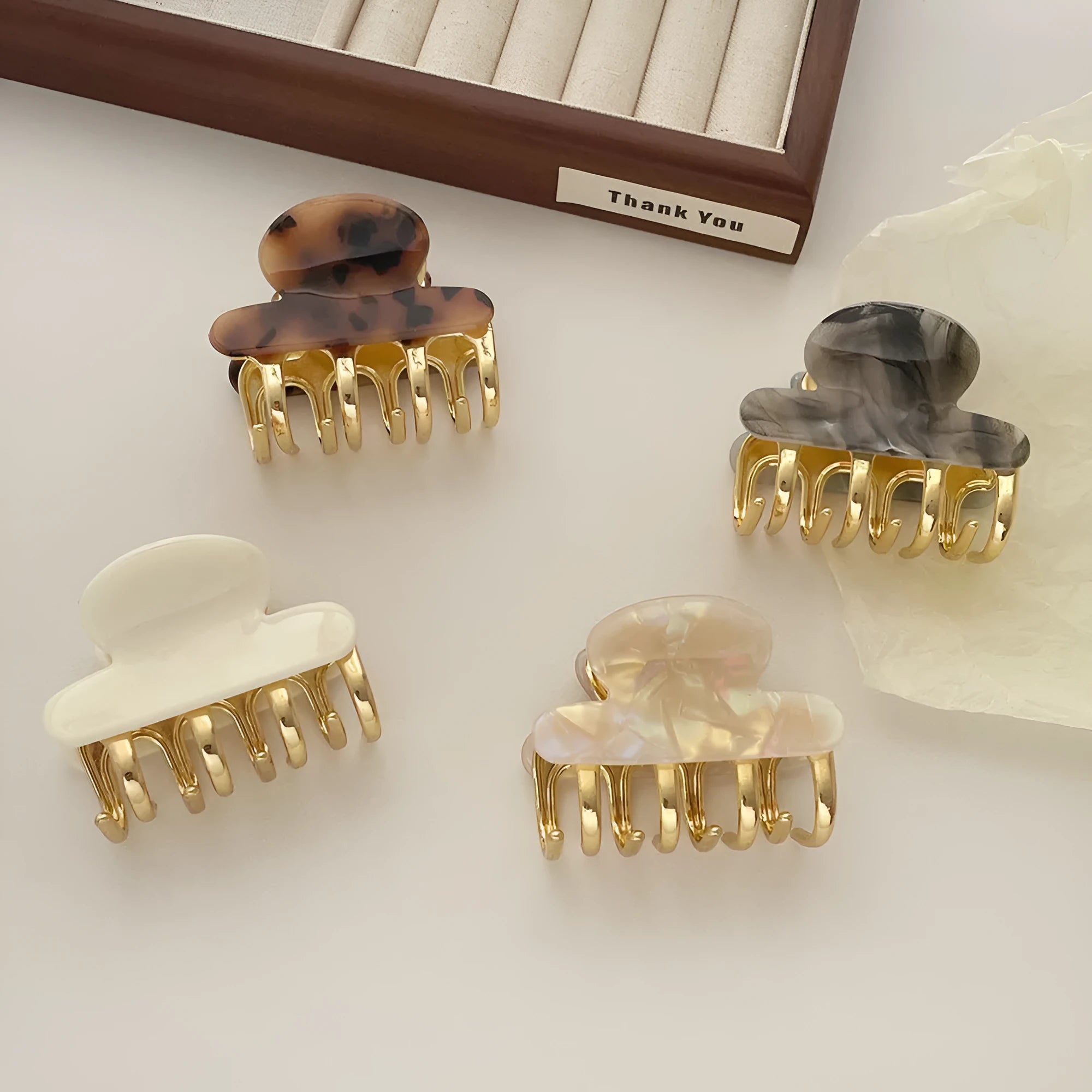 Set of four retro acetate hair barrettes with metal grip in beige, white, dark, and leopard print designs