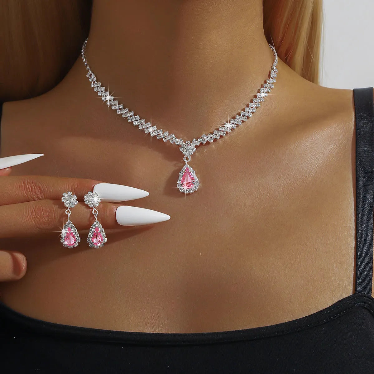Women's blue claw chain necklace and drop rhinestone earrings from a matching jewellery set.