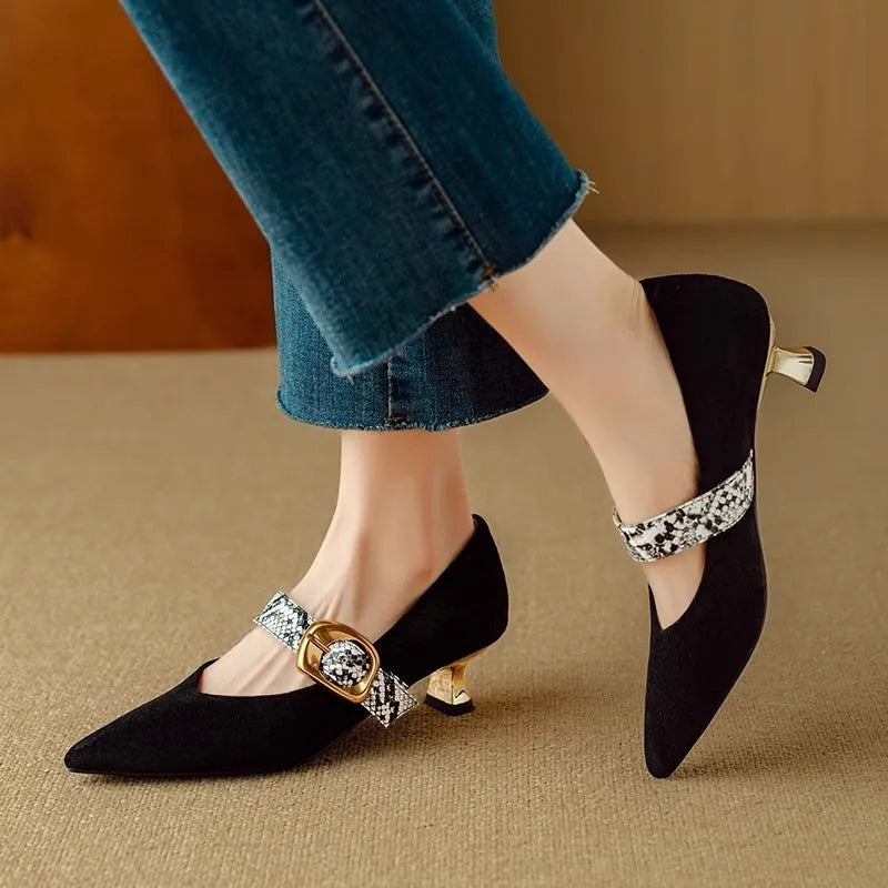 Women's black pointed toe stiletto heels with a buckle strap and a mid-height heel.