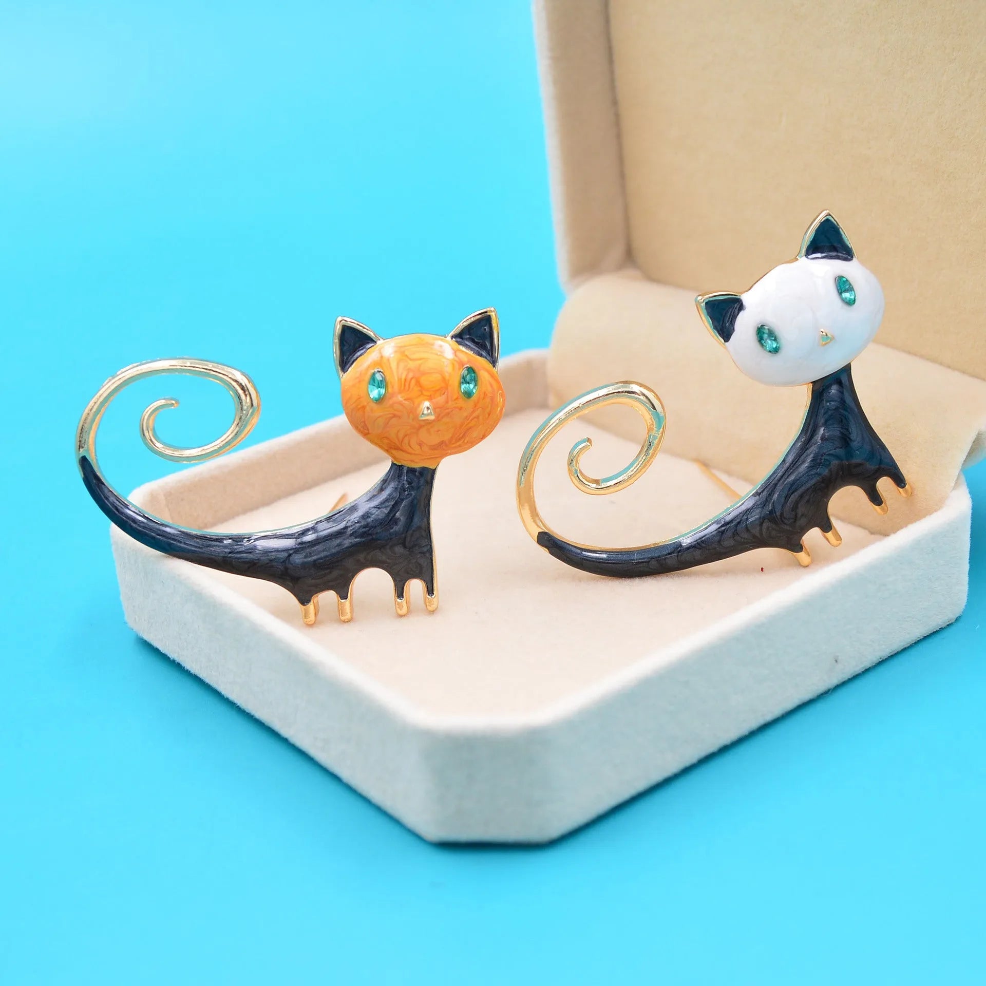 Close-up of a white painted cat tail brooch made from alloy metal.