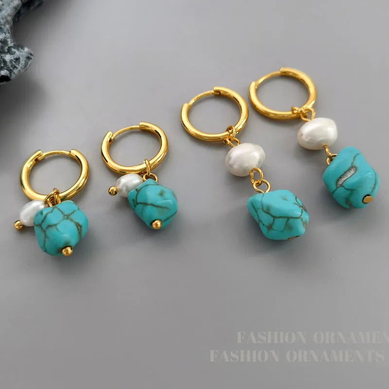 A pair of women's geometric drop earrings with irregular turquoise stones and round cultured pearls on copper settings.