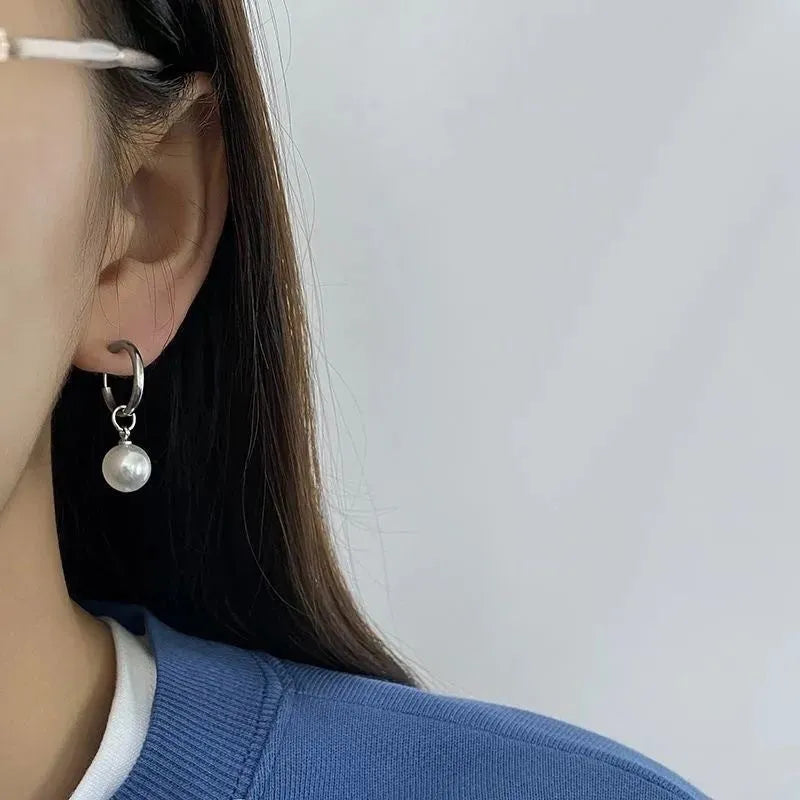 A pair of women's geometric alloy drop earrings with a round pearl centre and titanium steel post.