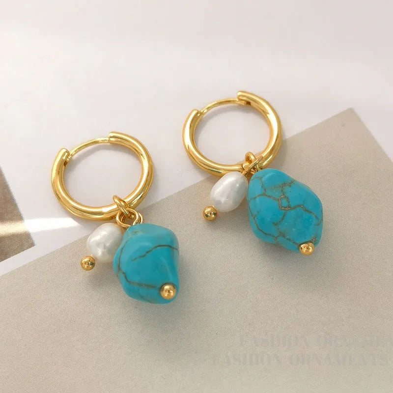 A pair of women's geometric drop earrings with irregular turquoise stones and round cultured pearls on copper settings.