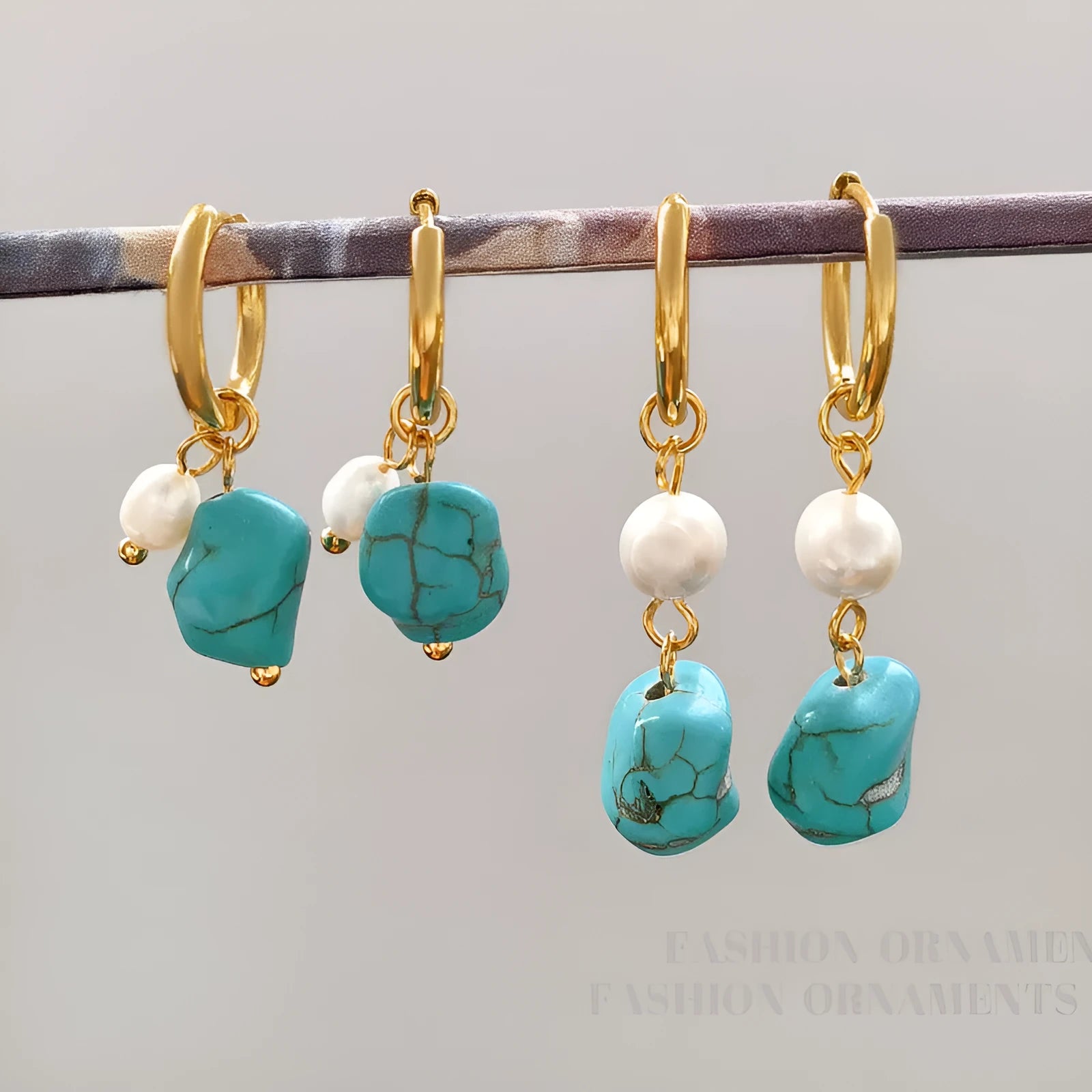 A pair of women's geometric drop earrings with irregular turquoise stones and round cultured pearls on copper settings.