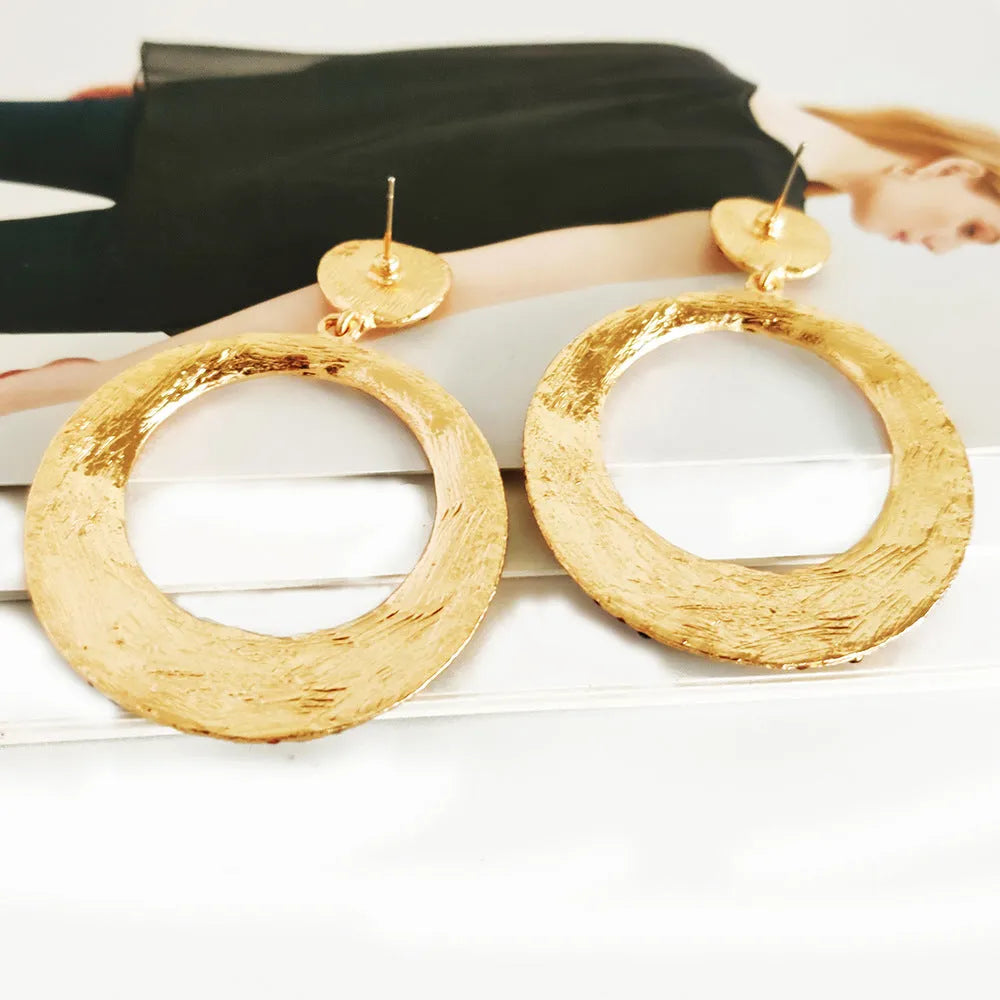 A pair of large colourful round pendant drop earrings with a cartoon style, made from metal alloy.