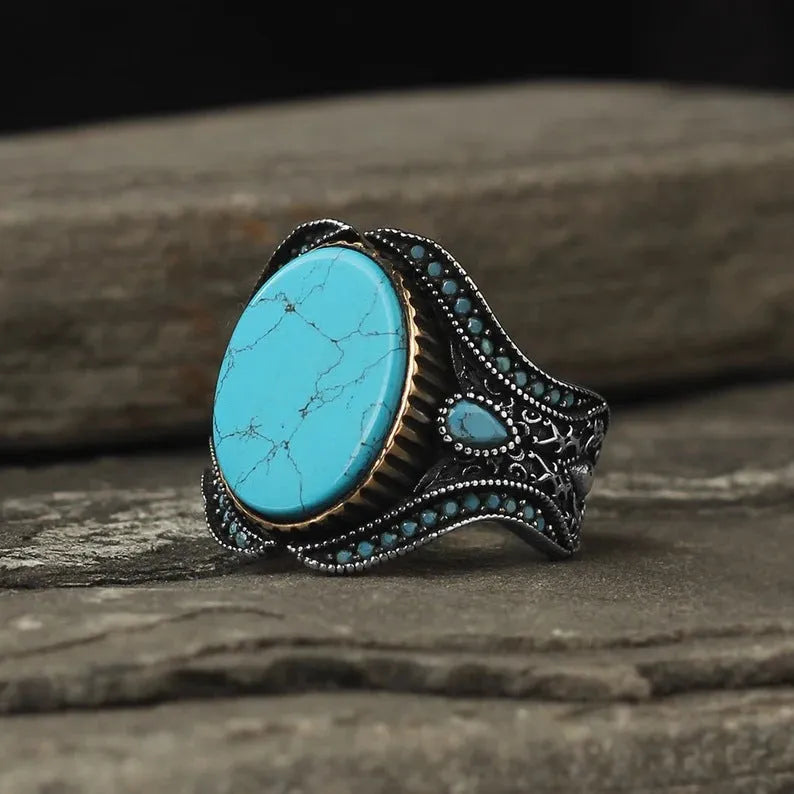 Men's round turquoise ring with antique silver finish showing circular alloy band design