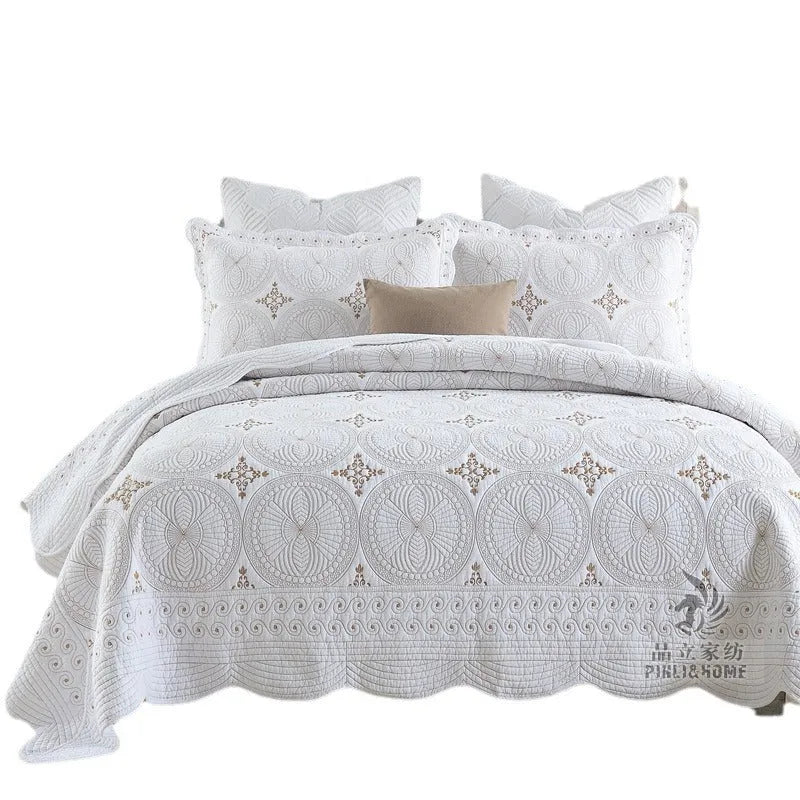Double thick pure cotton European-style embroidered bed cover set with two pillowcases on a bed.