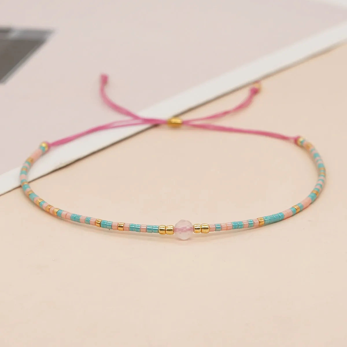 Women's handmade colourful beaded bracelet with geometric glass beads on adjustable cord
