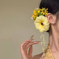Women's fairy-themed hair clip with long flower tassels and pearl details on a side clip fastener.