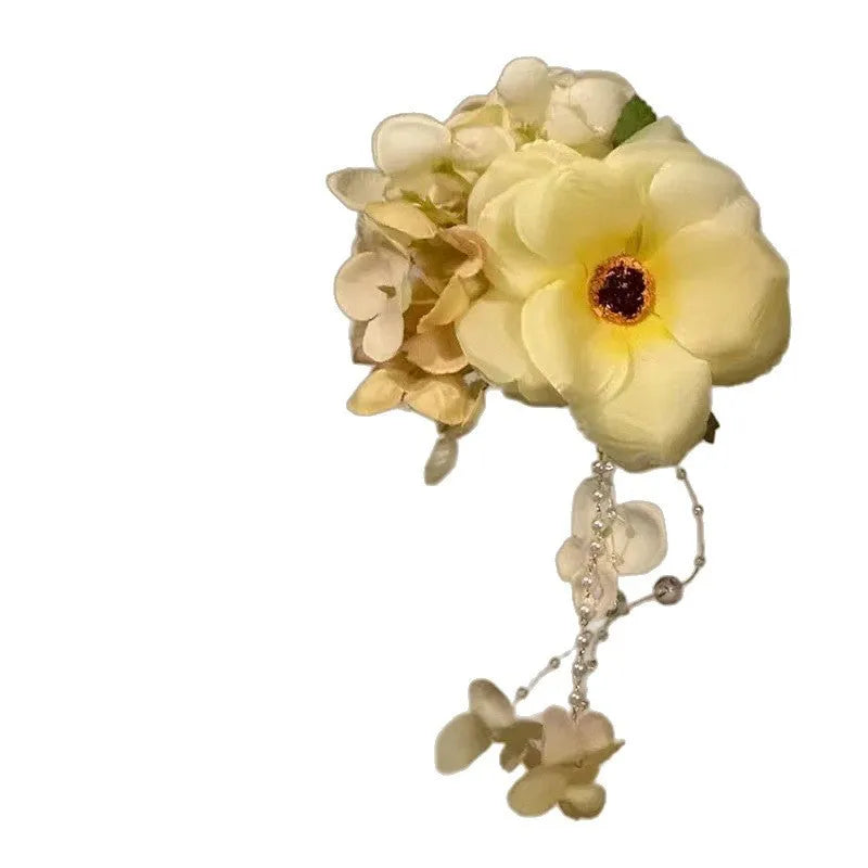Women's fairy-themed hair clip with long flower tassels and pearl details on a side clip fastener.